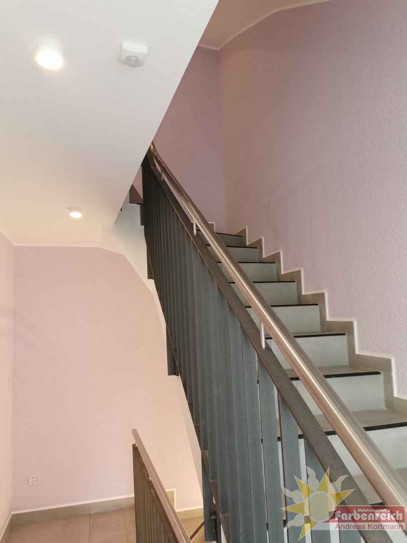 Kratzputz, im Farbton Flieder, Treppengeländer in Sandstrahloptik beschichtet,  stimmige Optik zu den sonst so oft tristen,  vernachlässigten Treppenhäusern.