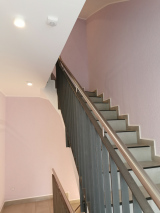 Kratzputz, im Farbton Flieder, Treppengeländer in Sandstrahloptik beschichtet,  stimmige Optik zu den sonst so oft tristen,  vernachlässigten Treppenhäusern.